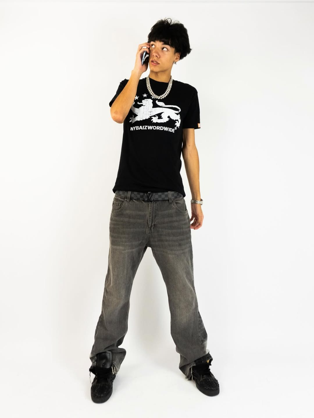 SlimeSanti holding a phone in a white studio